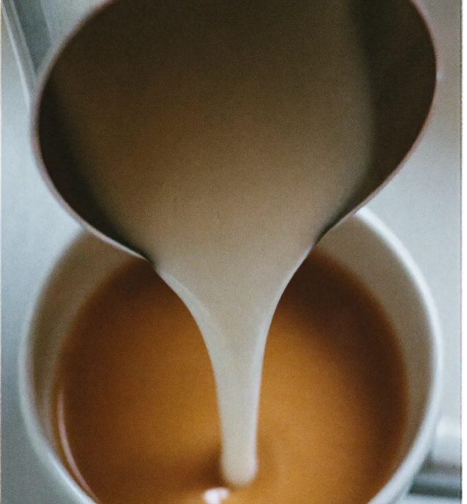 Milk being poured into a cup of coffee
