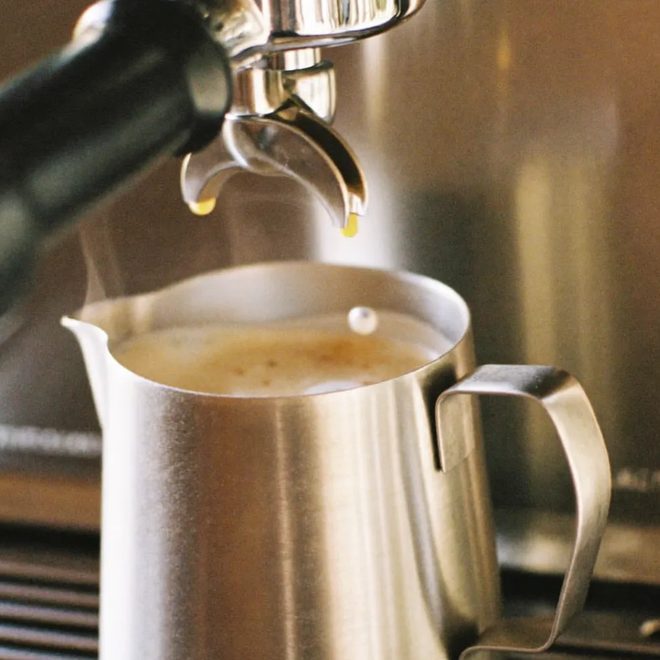 A jug of steamed milk at the espresso machine