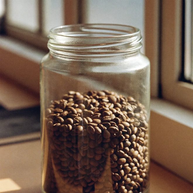 A jar of dark roasted coffee beans